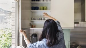mulher organizando armário da cozinha