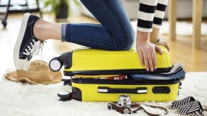 pessoa ajoelhada sobre mala de viagem
