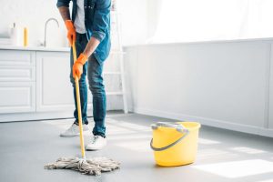 pessoa limpando piso de cimento queimado
