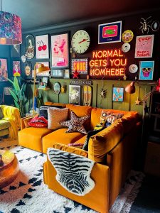 parede com vários quadros em sala de estar eclética