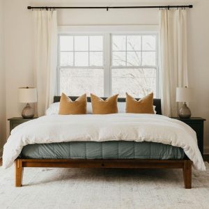 cama com almofadas em frente à janela