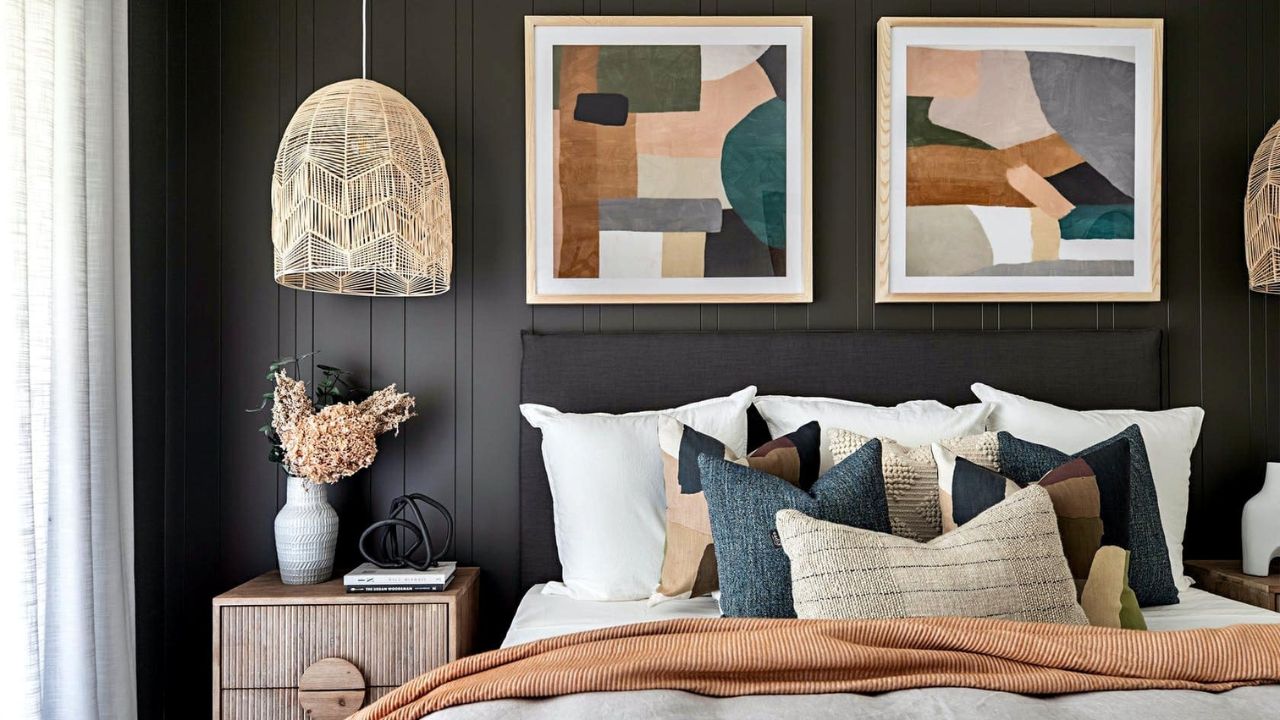 quarto com paredes escuras e quadros na cabecedeira