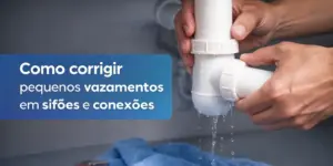 Mãos segurando dois canos brancos com vazamento em conector